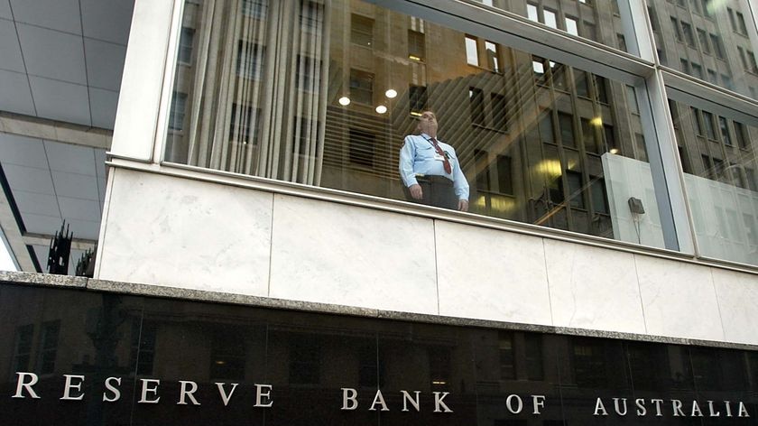 A security guard looks out the window of the Reserve Bank building