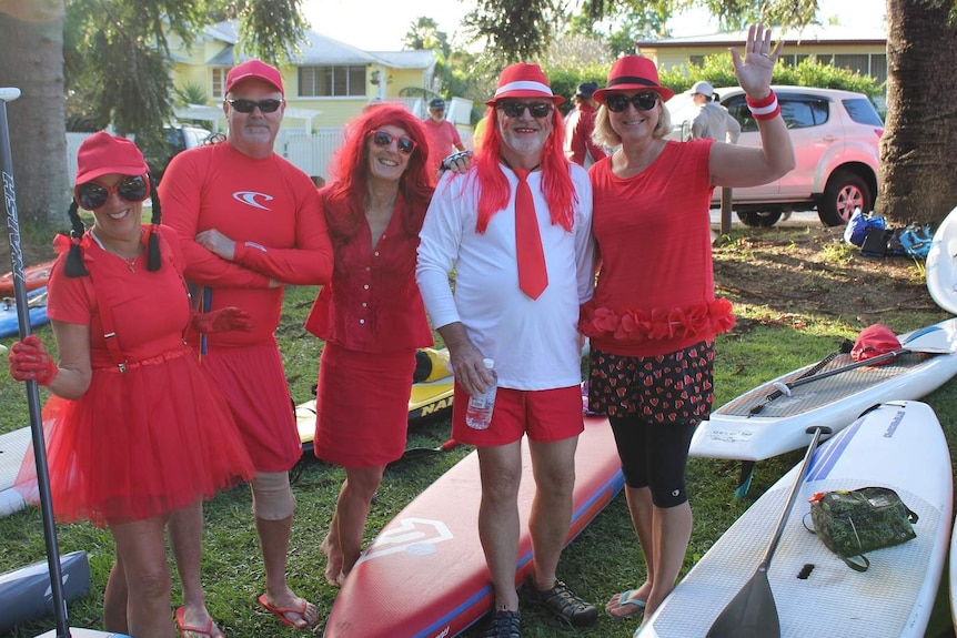 Group of paddlers wearing red wigs, glasses and clothes
