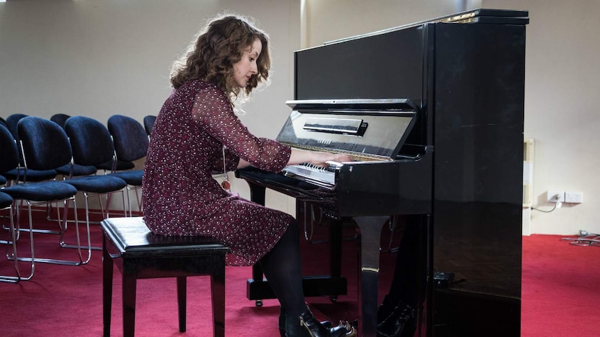 Pianist Julia Hastings plays in a small sunlit room.