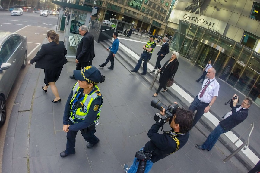 Media take photos of George Pell as he exits the Victorian County Court.