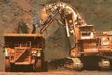 Iron ore is loaded into a large dump truck.
