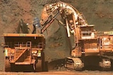 Iron ore is loaded into a large dump truck.
