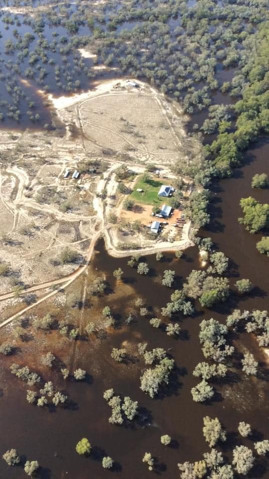 A view of a house surrounded by floodwaters taken from the sky