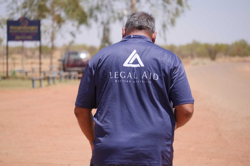 man walking with his back to camera, with Legal Aid Western Australia logo on his shirt