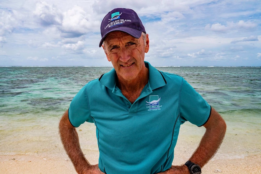 A man stands with reef behind him.