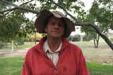 Farmer Pat Murphy poses in front of a tree