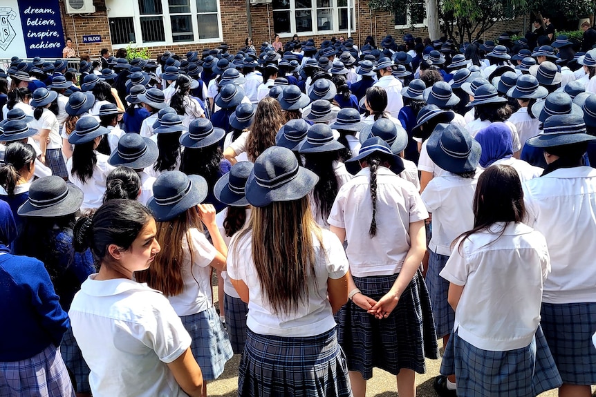 a group of school girls standing outdoors in the playground