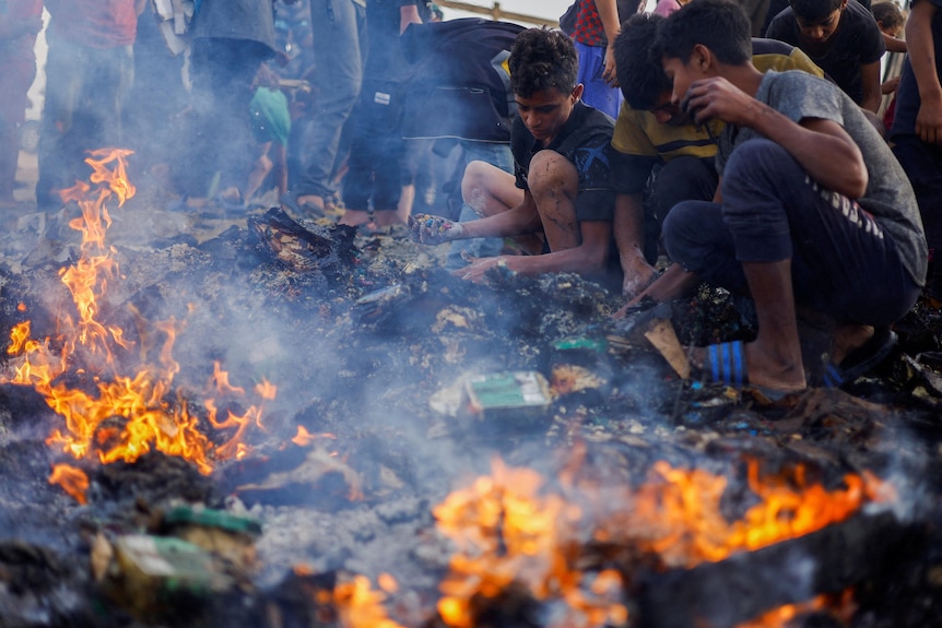 An image of fire and ashes. Next to it Palestinians searching through the ashes with their hands.