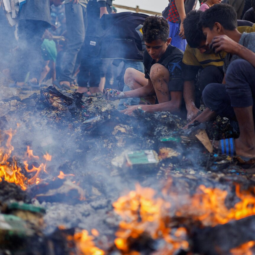 An image of fire and ashes. Next to it Palestinians searching through the ashes with their hands.