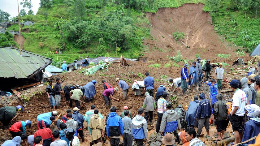 Volunteers and Indonesian soldiers search for missing people following a landslide in Java.