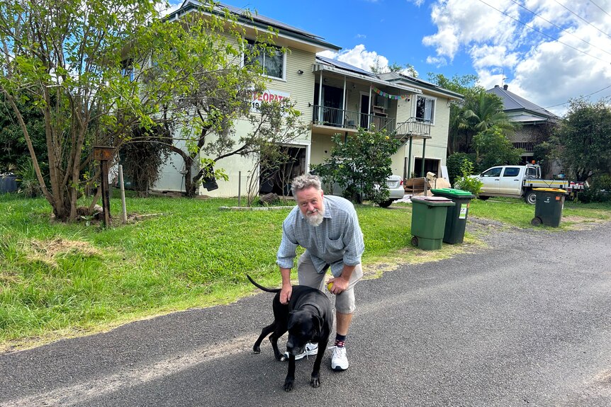 man with dog outside house