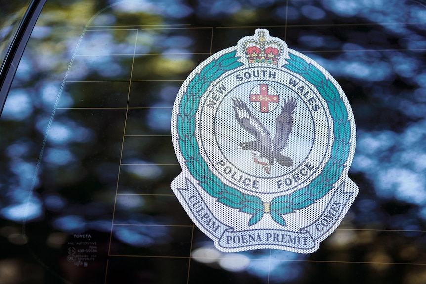 A close-up of the NSW Polic logo on a window.
