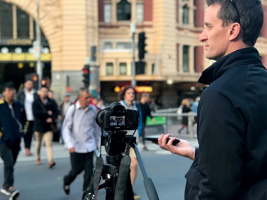 The ABC's Kyle Harley mans the camera at Flinders Street crossing.