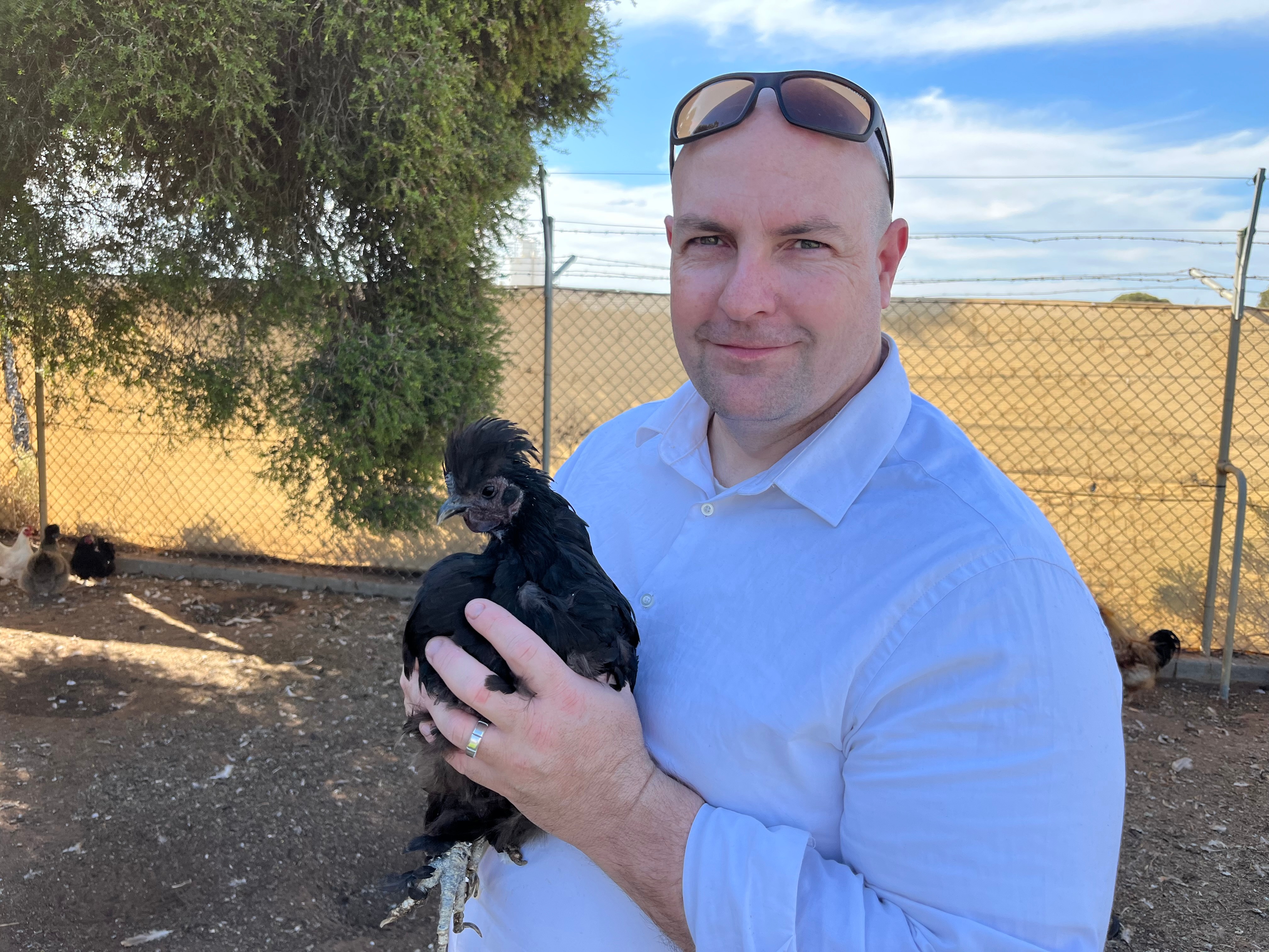 Matthew Carlin holds a black chicken