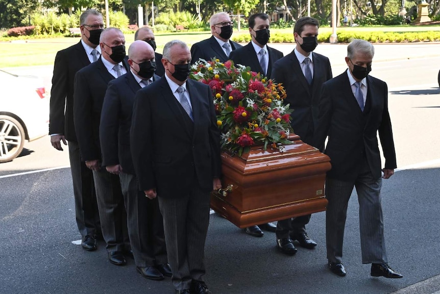 A group of men carry a casket