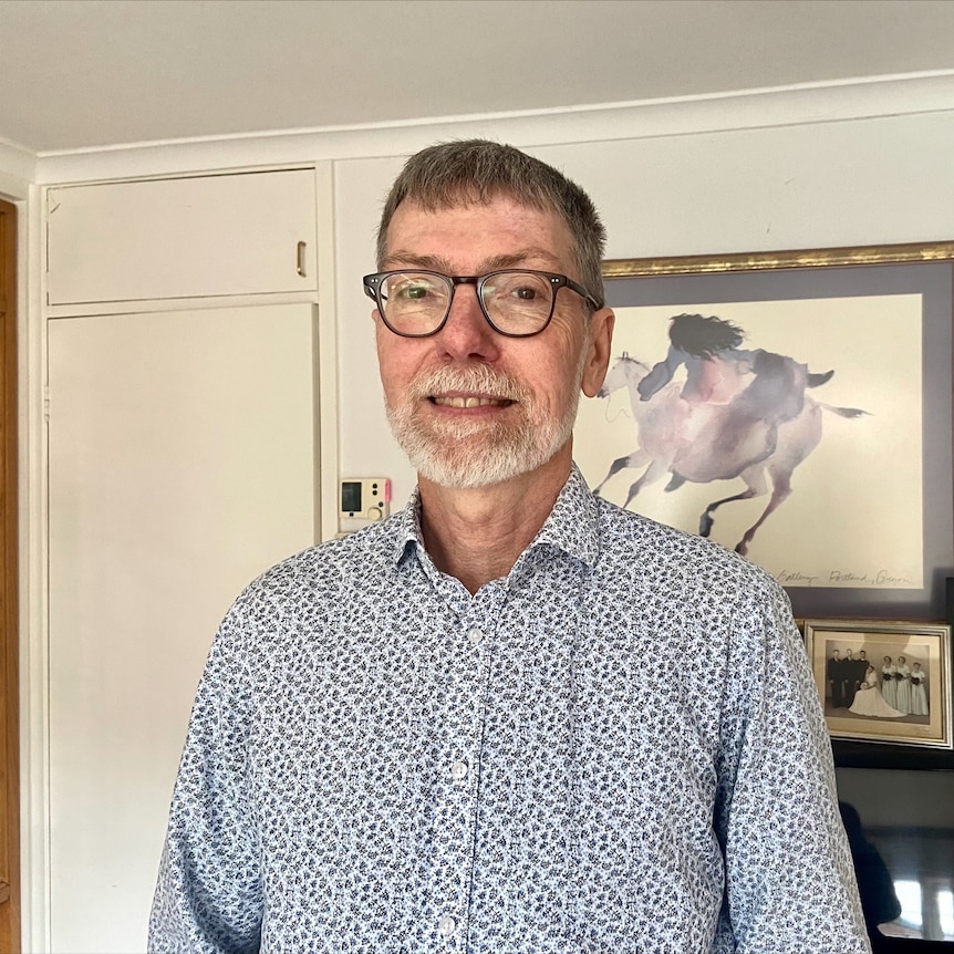 Un homme avec des cheveux gris et des lunettes.