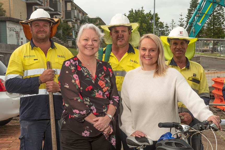 Three male council construction workers pictured with two female elected councillors.