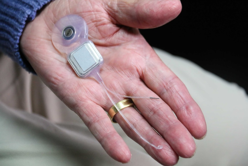 Dr Rice holds his cochlear implant. Ausnew Home Care, NDIS registered provider, My Aged Care