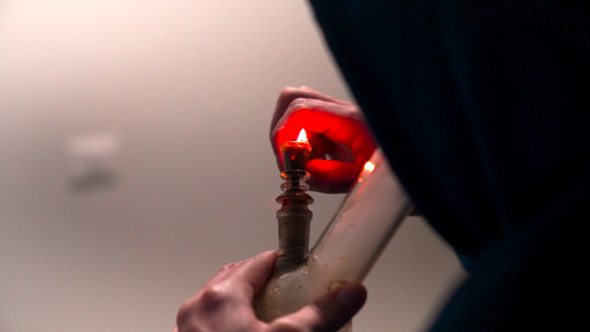 Man lighting a bong with cannabis inside