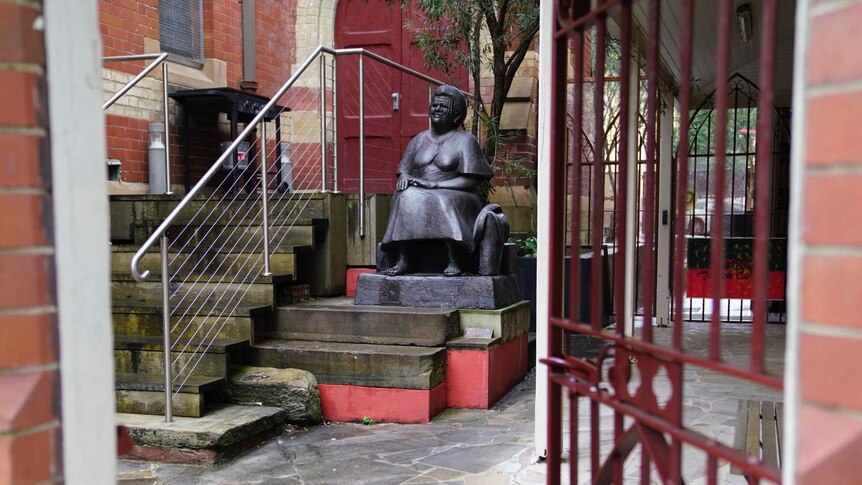 A statue sits beside a church
