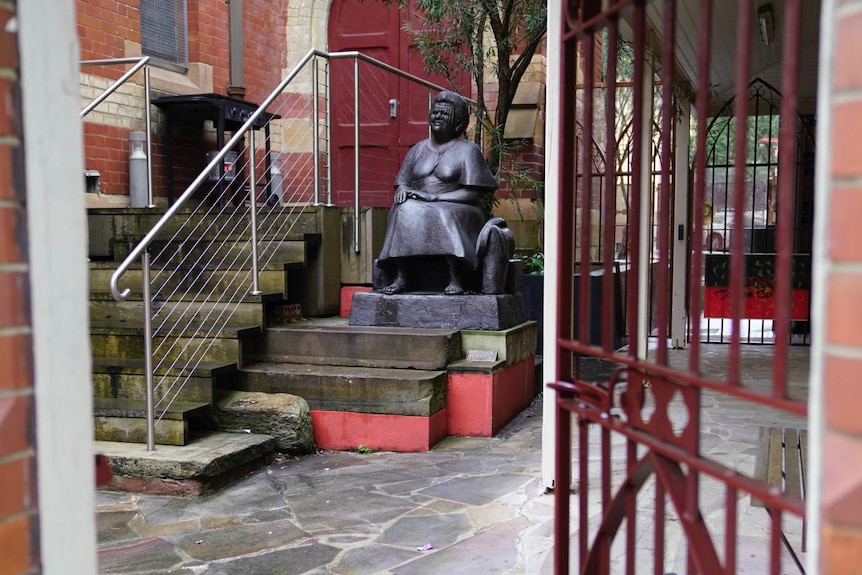 A statue sits beside a church