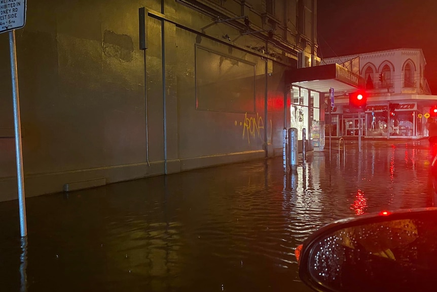 A suburban intersection covered in water at night.