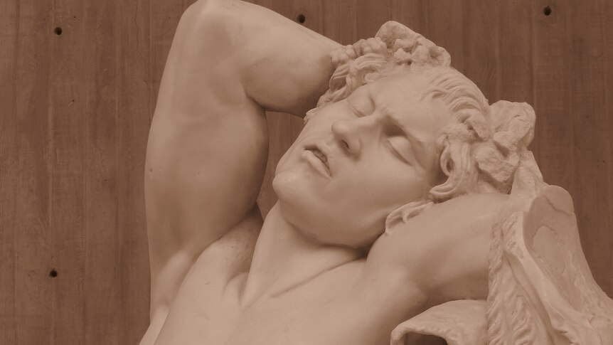 A marble sculpture of a faun asleep.