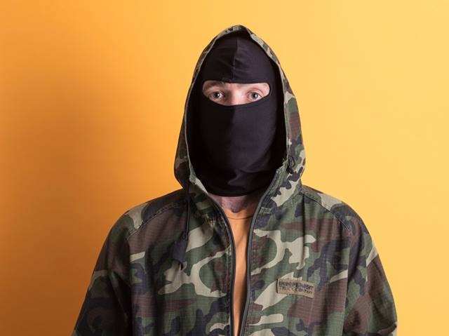 Portrait of H-Foot, an anonymous graffiti artist from Newcastle, with face hidden by a balaclava.