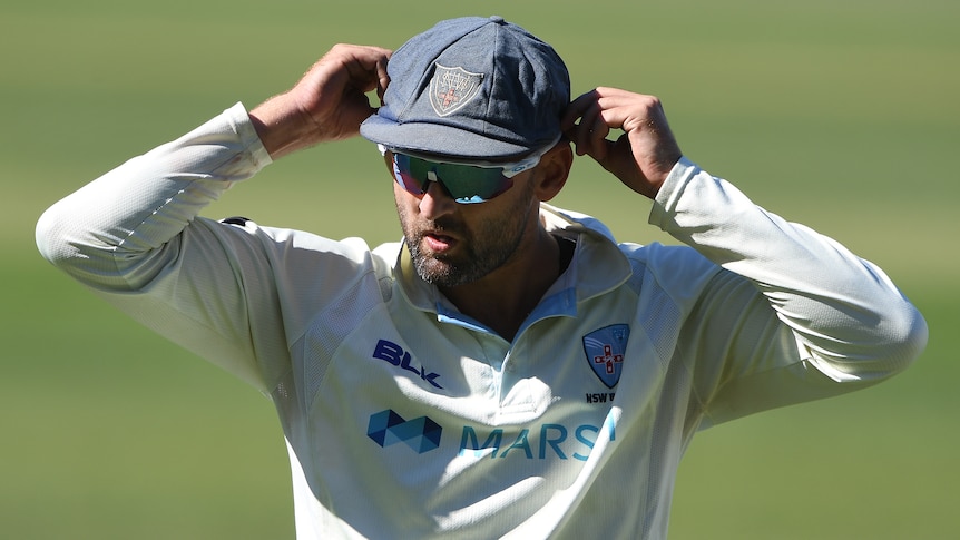 Cricket player with his hands on his head during a match