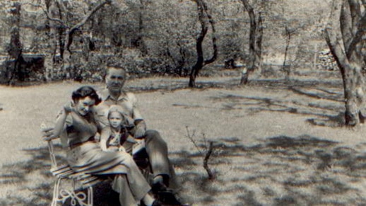 Black and white photo of Kruszelnicki family sitting on outside chair.