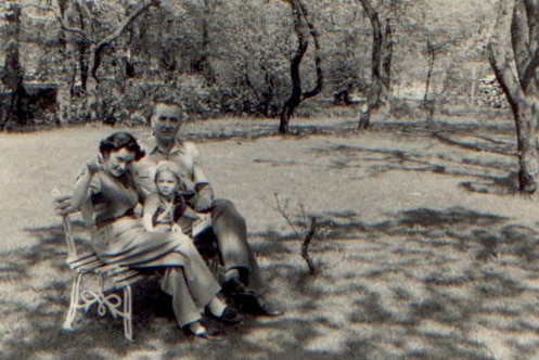 Black and white photo of Kruszelnicki family sitting on outside chair.