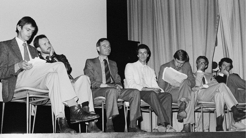 A panel of doctors speaks to a crowd about the HIV/AIDS epidemic.