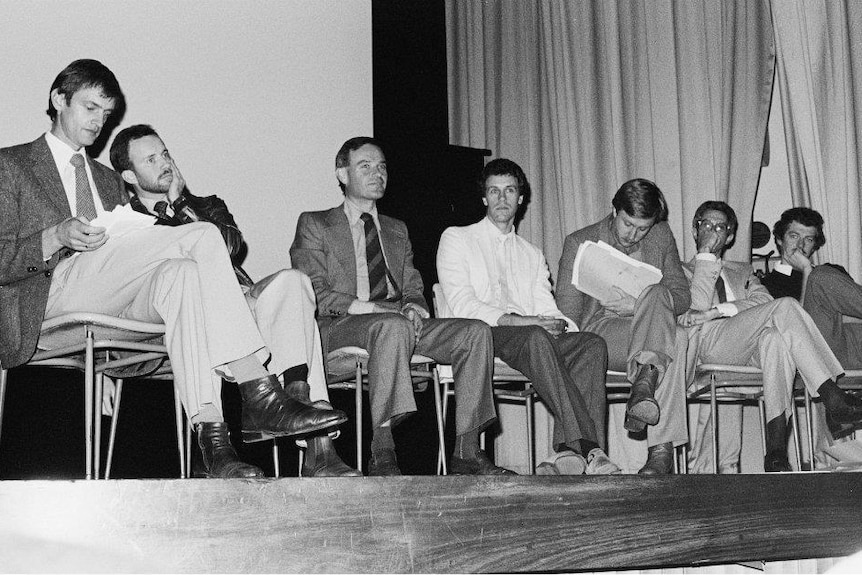 A panel of doctors speaks to a crowd about the HIV/AIDS epidemic.