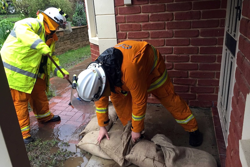 CFS members sandbag the front step of a home.