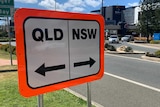A road sign that reads "Qld" and "NSW".