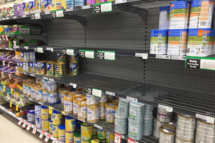 Empty shelves in the baby formula aisle of a supermarket.
