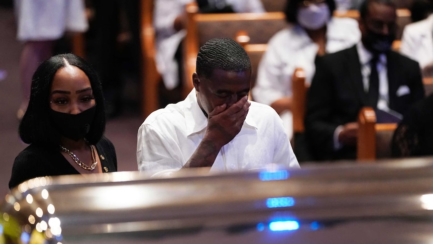 Mourners pause by the casket of George Floyd during a funeral service for Mr Floyd at The Fountain of Praise church.