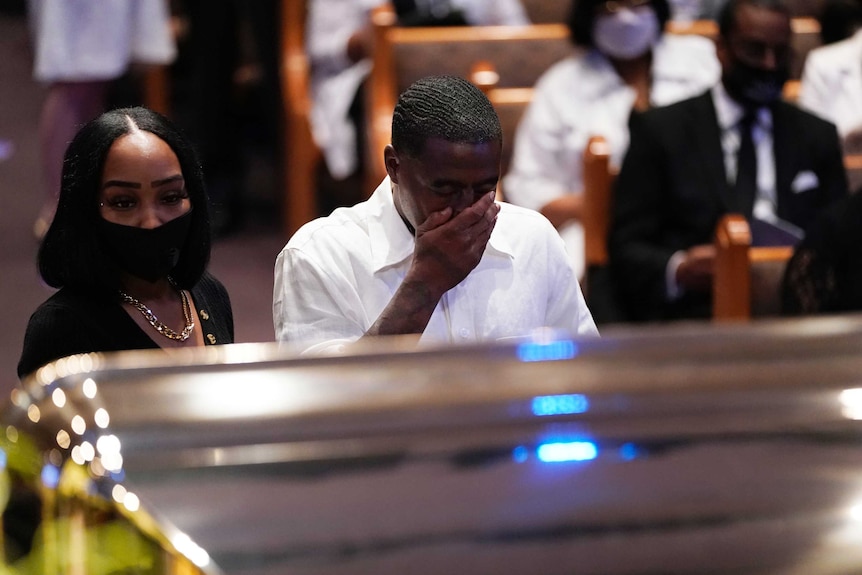 Mourners pause by the casket of George Floyd during a funeral service for Mr Floyd at The Fountain of Praise church.