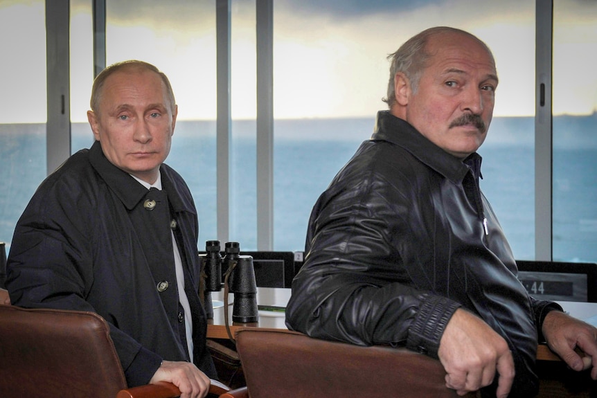 Vladimir Putin and Alexander Lukashenko seated near a window overlooking the sea