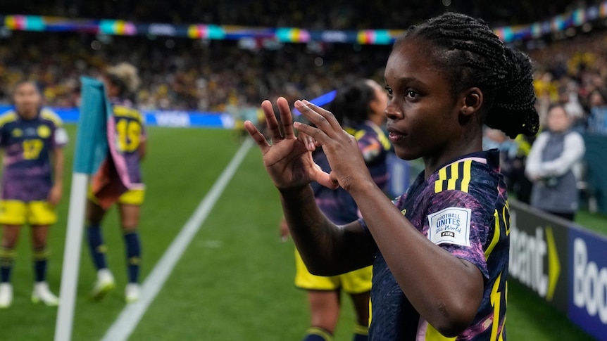 A Colombian footballer makes a heart sign with her fingers after scoring at the Women's World Cup.