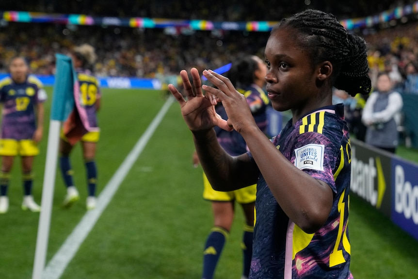 A Colombian footballer makes a heart sign with her fingers after scoring at the Women's World Cup.