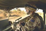 A Royal Australian Air Force squadron leader keeps watch from the back of his vehicle