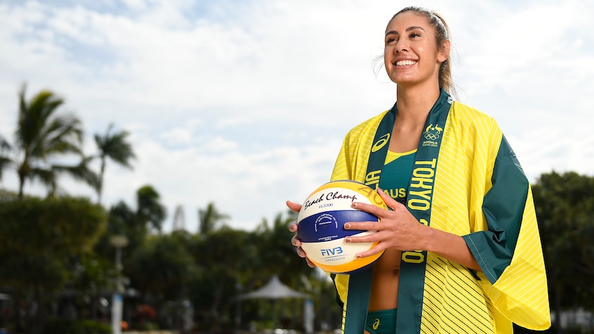 Female volleyball player posing for a photo with the ball in her hand