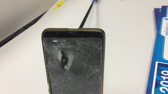 A mobile phone with a shattered screen protector and an arrow protruding out of it