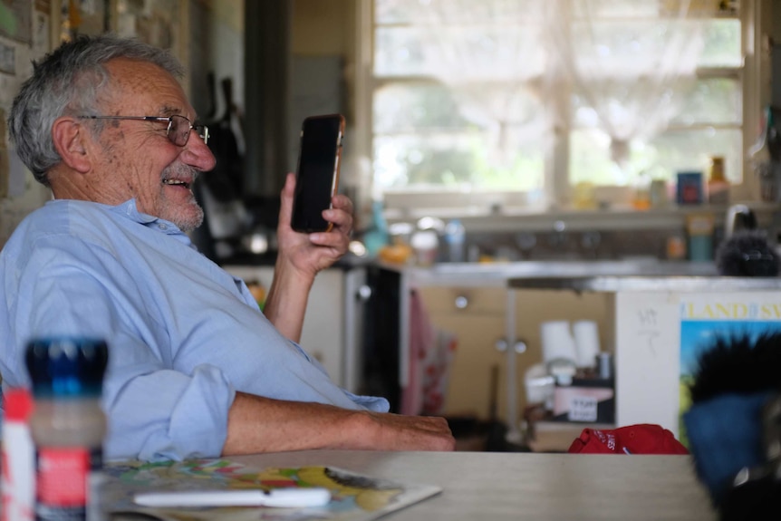 Ben Buckley sitting at a table in his kitchen on the phone.