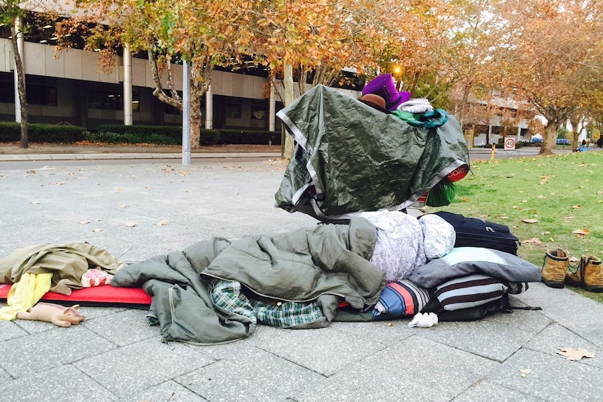 A homeless man sleeps on the street in Perth,