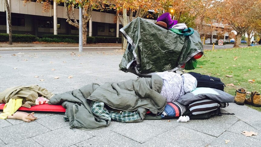 A homeless man sleeps on the street in Perth