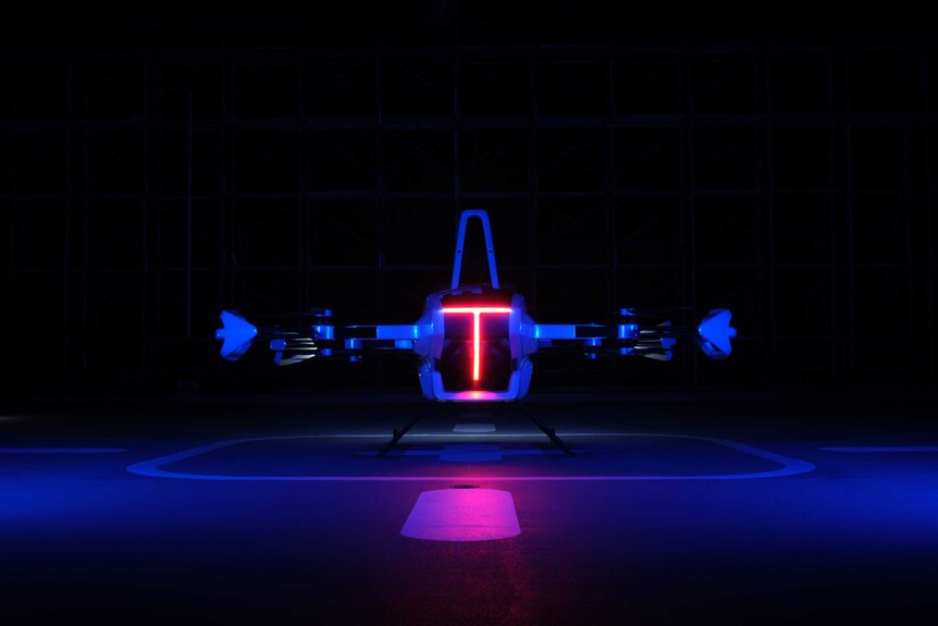 An image of a grounded flying car lit up by sensor lights