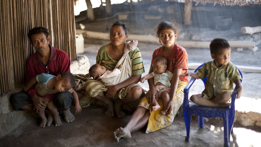 Two women and a man are pictured with four young children.