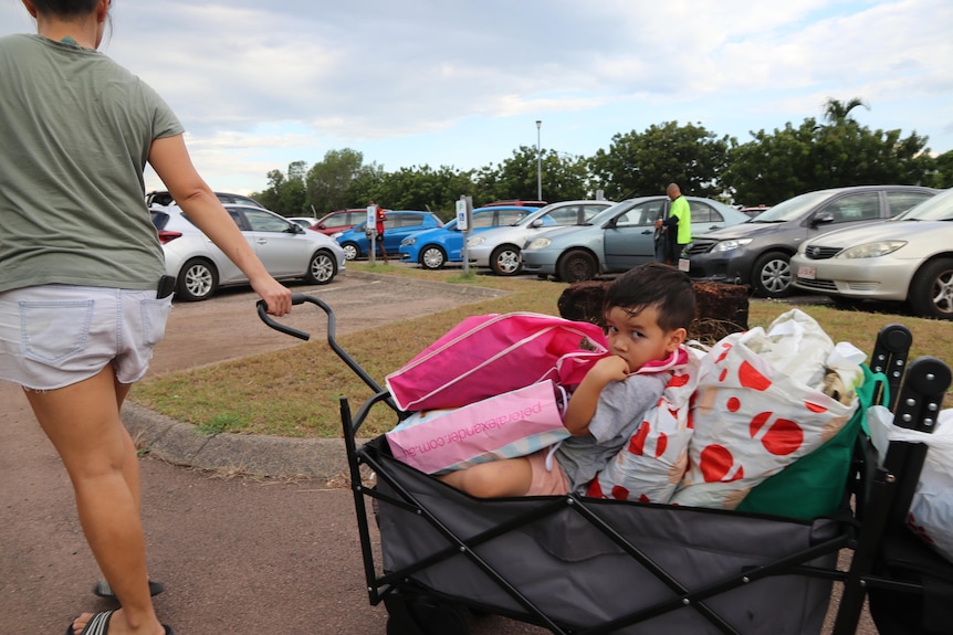 A mother drags her child along in a trolley full of donations for Timor-Leste.